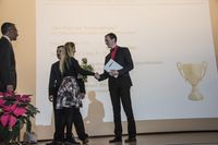Foto: Ein Absolvent bekommt Blumen überreicht.