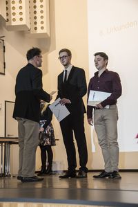 Foto: Absolventen erhalten eine persönliche Gratulation und bekommen ihre Urkunden überreicht.