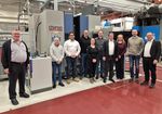Eine Personengruppe steht in einer Laborhalle für Maschinenbau.