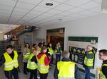 Foto: Eine Gruppe Studierender stehtt bei einem Werksbesuch und erhält gerade einen Vortrag.