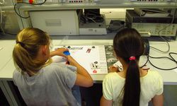 Foto: Zwei Schülerinnen basteln an einem Tisch in der Elektrotechnik.