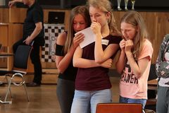 Foto: Drei Schülerinnen stehen gespannt zusammen und drücken die Daumen.