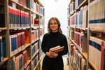 Eine Studentin steht in der Hochschulbibliothek.