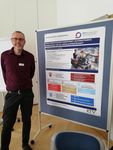 Ein Wissenschaftler steht vor einem Poster