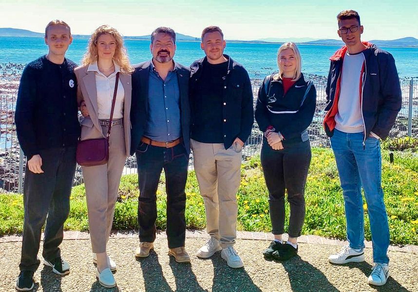 Gruppenbild von Studierenden und Mitarbeitern, im Hintergrund das Meer. 