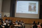 Foto: Studierende und Gäste sitzen in der Aula Scheffelberg und hören einem Vortrag zu.