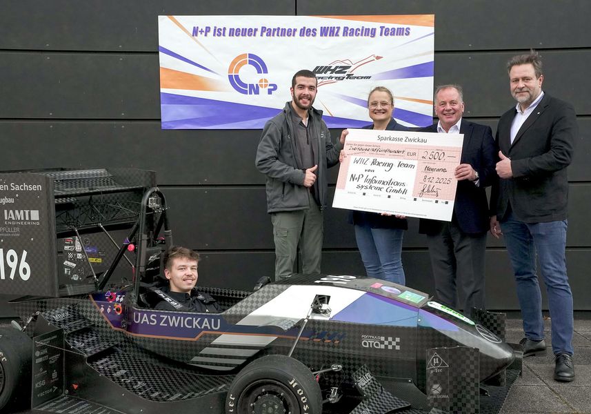 Personen halten einen symbolische Scheck in der Hand, im Vordergrund ein Fahrzeug des WHZ Racing Teams. 