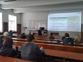 Foto: Studierende sitzen in einem Lehrraum und hören einer Vorlesung zu.