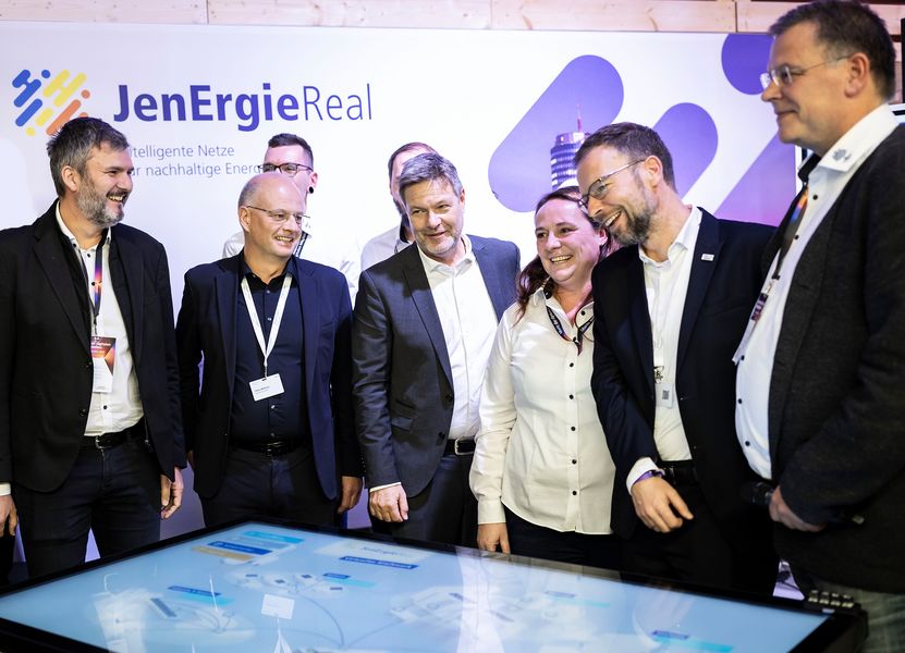 Bundeswirtschaftsminister Robert Habeck steht mit Projektmitarbeitern am Stand der Stadtwerke Jena 