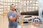 Foto: Person an Metallkonstruktion schaut in die Kamera