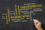 Grafik: Auf einer Tafel stehen verschiedene Begriffe zum Thema Arbeits- und Gesundheitsschutz.