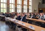 Auditorium einer Konferenz sitzend an Tischen