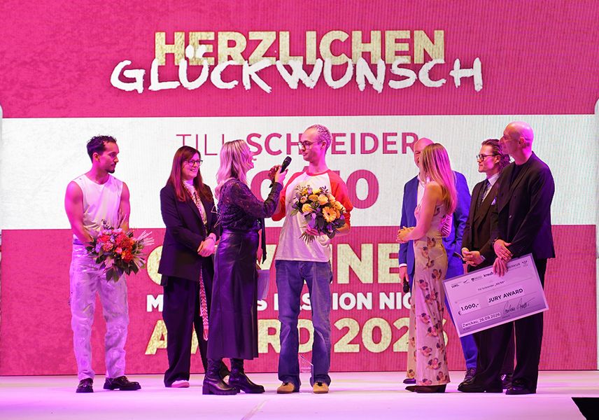 Ein Designer wird auf dem Laufsteg ausgezeichnet. 