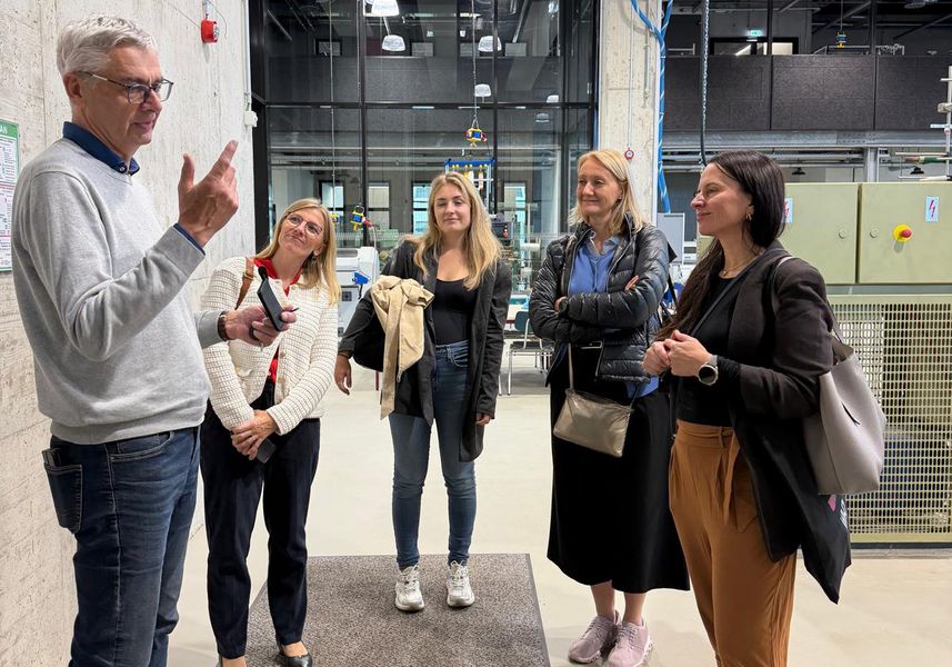 Eine Gruppe von Personen besichtigt eine Laborhalle. 