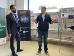 Foto: Zwei Männer im Gespräch stehen vor einer technischen Anlage.