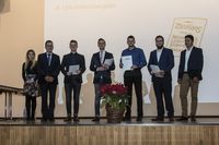 Gruppenfoto: Fünf Absolventen präsentieren mit dem Gratulanten ihre Urkunden.
