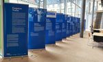Blaue Roll-Ups mit Bildern und Texten stehen in einem modernen Raum.