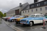 Historische Fahrzeuge stehen auf einem Parkplatz.