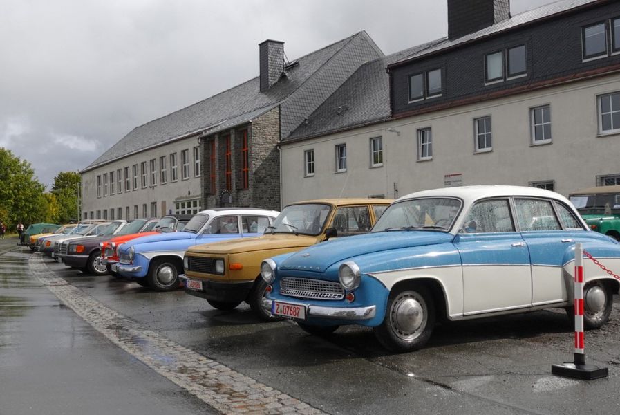 Historische Fahrzeuge stehen auf einem Parkplatz. 