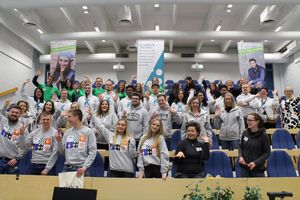 Gruppenfoto: In den Stuhlreihen eines Hörsaales stehen die Studierenden.
