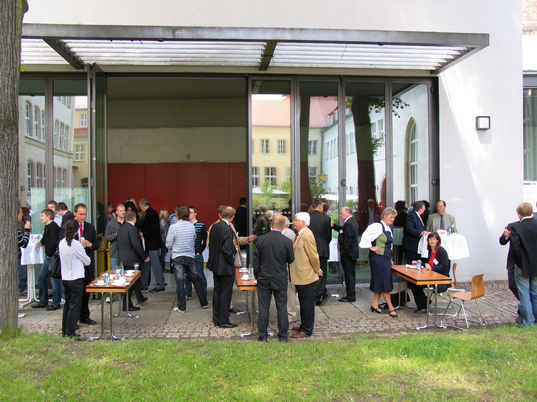 Foto: Teilnehmer vor dem Eingangsbereich bei einer Kaffeepause.