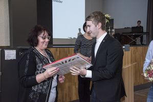 Foto: Eine Frau bekommt ein Präsent überreicht.