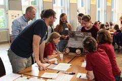 Foto: Eine Schülerin präsentiert vor einer Jury ihr Solar Modellauto.