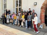 Junge Menschen stehen für ein Gruppenfoto vor einem alten Gebäude.