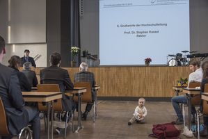 Foto: Absolventen sitzen in der Aula Scheffelberg. Am Rednerpult Prof. Dr. Stephan Kassel.
