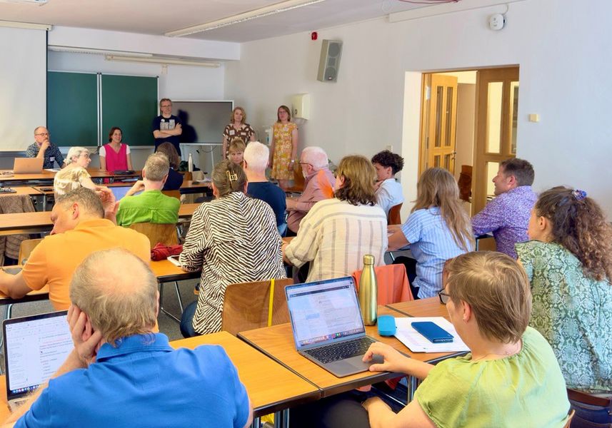 Personen sitzen in einem Seminarraum. 