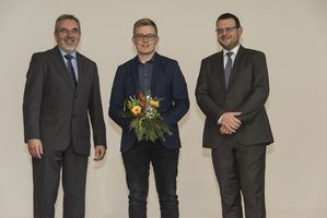 Foto: Gruppenbild. Ein Absolvent und zwei Herren.