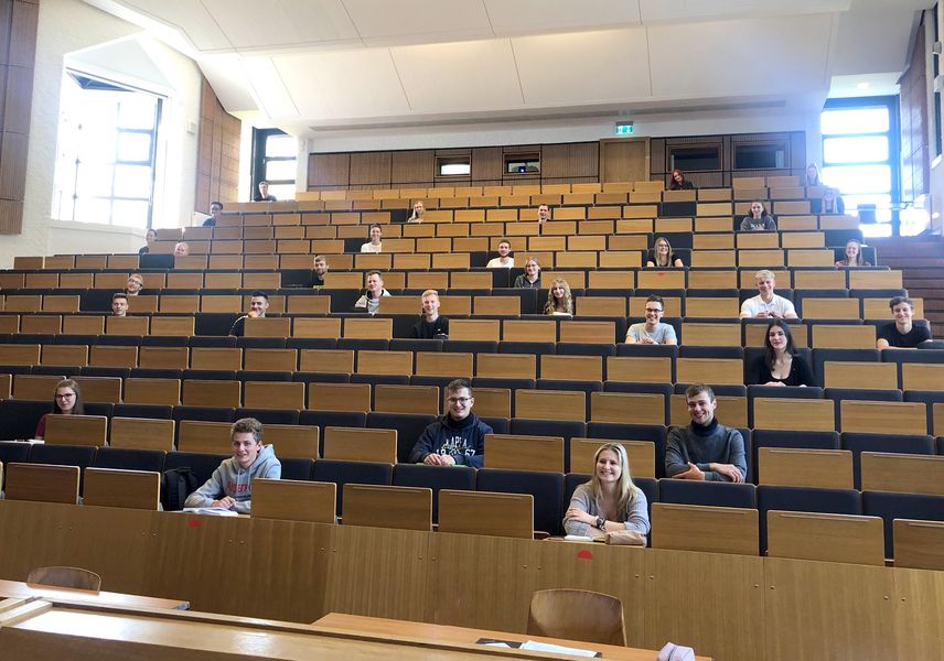 Foto: Studierende sitzen im Hörsaal. Aufgrund der Corona-Beschränkungen sitzen die Studierenden in sehr großen Abständen. 