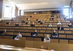 Foto: Studierende sitzen im Hörsaal. Aufgrund der Corona-Beschränkungen sitzen die Studierenden in sehr großen Abständen.
