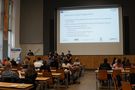 Foto: Studierende und Gäste sitzen in der Aula Scheffelberg und hören einem Vortrag zu.