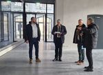 Vier Personen stehen in einem Foyer une sprechen über den Baufortschritt.