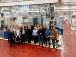 Eine Personengruppe steht in der Maschinenhalle der Fakultät Automobil- und Maschinenbau der WHZ.