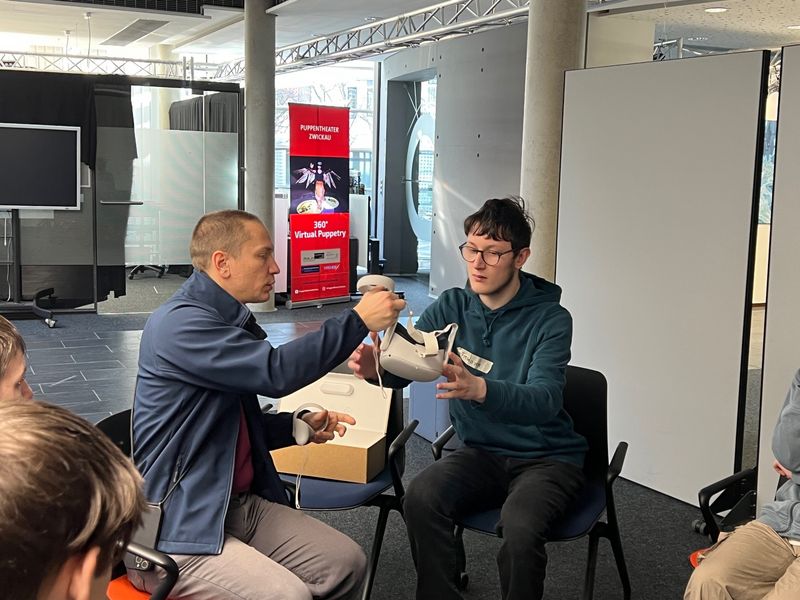 Prof. Sven Hellbach, Wissenschaftlicher Berater des WHZ-Schüler-Labs erklärt die Nutzung der VR-Brille (Foto: S. Dinger/WHZ)