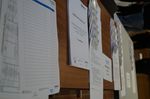 Foto: Auf einem Tisch liegen Handout´s, Namenschilder, Listen und Schriftreihen.
