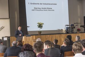 Foto: Absolventen sitzen in der Aula Scheffelberg. Am Rednerpult Dipl-Ing. André Kleine.