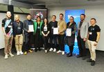 Gruppenfoto. Einige Teilnehmer halten Urkunden in den Händen.
