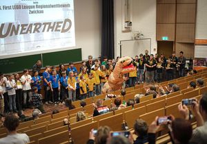 Kinder verschiedener Teams stehen in einem Hörsaal