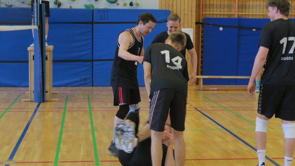 Volleyballer wird vom Boden aufgeholfen