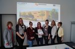 Foto: Gruppenbild vor einer Präsentationsprojektion.