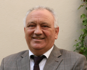 Foto von Prof. Dr.-Ing. habil. Prof. E. h. Dr. h. c. mult. Cornel Stan im Anzug vor einer Wand 