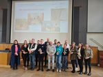 Projektgruppe steht gemeinsam vor einer Bühne