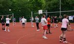 Personen spielen Volleyball auf einem Kleinfeld im Freien.