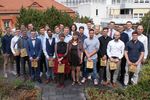 Auf einer Dachterasse stehen 26 junge Menschen.