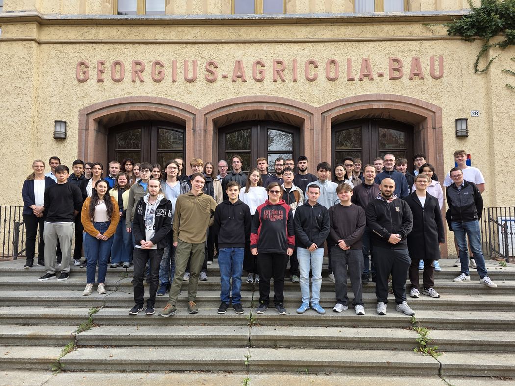 Foto: Gruppenfoto der Erstsemester-Studierenden und der Lehrenden aus dem WS 2025/26 vor dem Eingang des Georgius-Agricola-Baus der WHZ