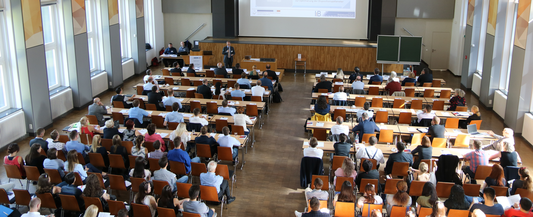 Foto: Teilnehmer sitzen in der Aula Scheffelberg und hören einem Vortrag zu.