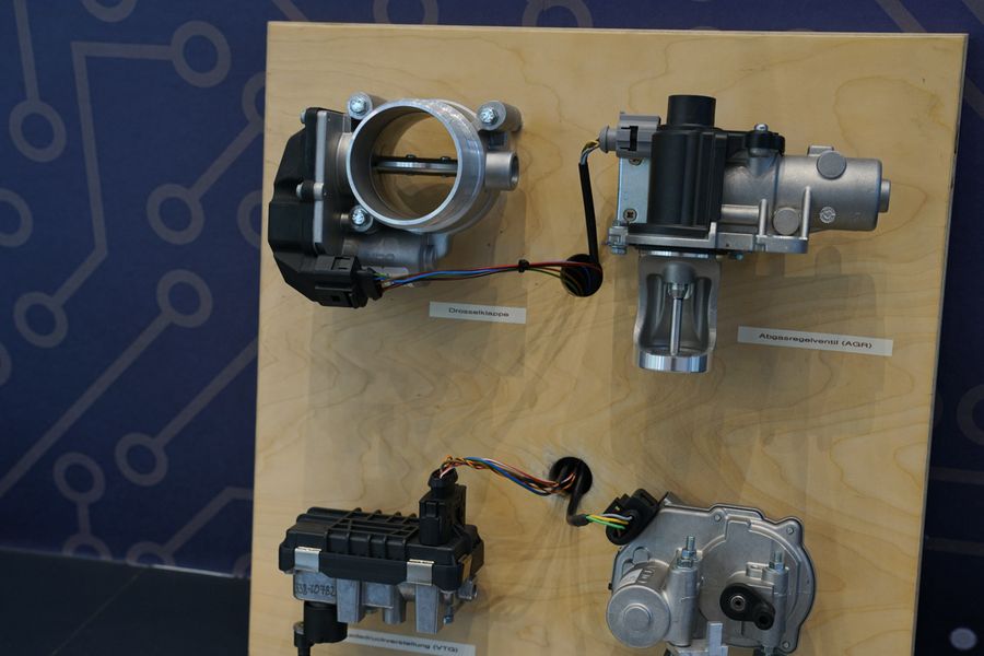 Aufm dem Bild sieht man einen Teil des ausgestellten HiL-Generators. Es ist eine Holzplatte mit vier Bauteilen.